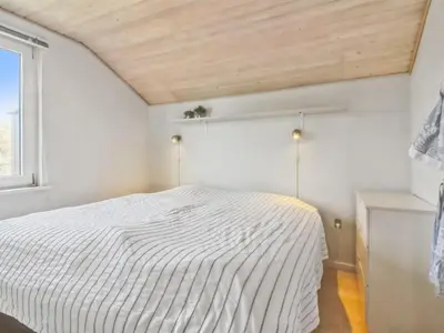 a bedroom with a white bed and a window at Holiday Home Madsen - 500m from the sea by Interhome in Thisted