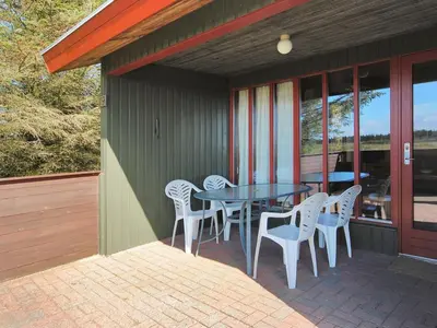 a patio with a table and chairs on a porch at Holiday Home Neven - 900m from the sea by Interhome in Torsted