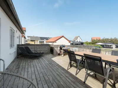 a wooden deck with a table and chairs on it at Holiday Home Thilla - 100m from the sea by Interhome in Thisted