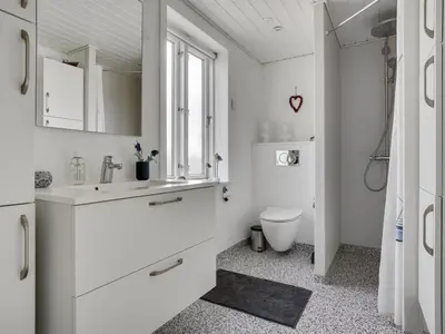 a white bathroom with a sink and a toilet at Holiday Home Thilla - 100m from the sea by Interhome in Thisted