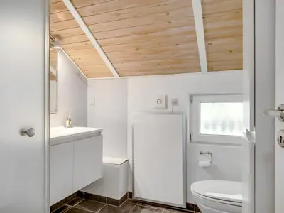 a bathroom with a white toilet and a sink at Holiday Home Eisa - 300m to the fjord by Interhome in Øsløs