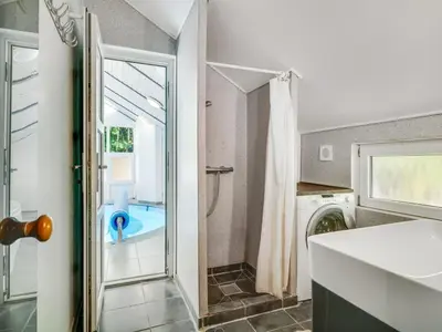 a bathroom with a shower and a washing machine at Holiday Home Eisa - 300m to the fjord by Interhome in Øsløs