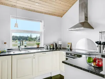 a kitchen with white cabinets and a window at Holiday Home Sulki - 3-5km from the sea by Interhome in Frøstrup