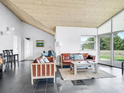 a living room with couches and a table at Holiday Home Sulki - 3-5km from the sea by Interhome in Frøstrup