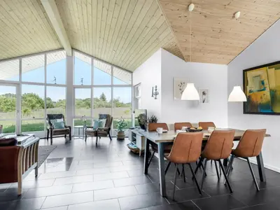 a dining room with a table and chairs at Holiday Home Sulki - 3-5km from the sea by Interhome in Frøstrup