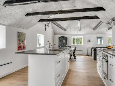 a kitchen with white cabinets and a ceiling with exposed beams at Holiday Home Elisa - 1-2km from the sea by Interhome in Bedsted Thy