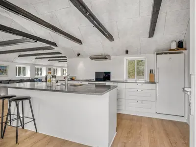 a kitchen with white cabinets and a large island at Holiday Home Elisa - 1-2km from the sea by Interhome in Bedsted Thy