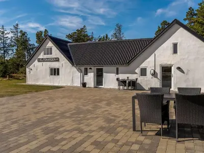 a white barn with a table and chairs at Holiday Home Elisa - 1-2km from the sea by Interhome in Bedsted Thy