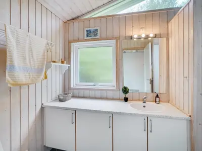 a bathroom with a sink and a window at Holiday Home Aameek - 3km from the sea by Interhome in Frøstrup