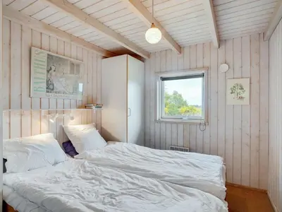 a bedroom with two beds and a window at Holiday Home Aameek - 3km from the sea by Interhome in Frøstrup