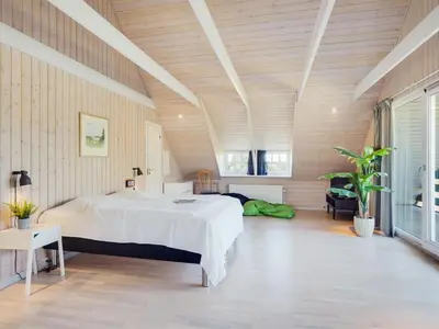 a bedroom with a large bed in a room with wooden walls at Holiday Home Gertrudis - 2km to the fjord by Interhome in Frøstrup