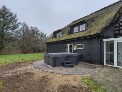 a large black building with a grill in front of it at Holiday Home Gertrudis - 2km to the fjord by Interhome in Frøstrup