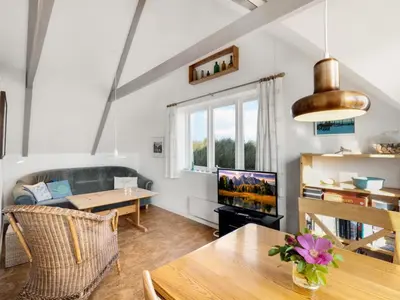 a living room with a couch and a table at Holiday Home Ebba - 25m from the sea by Interhome in Frøstrup