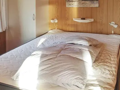 a bed with white sheets and pillows on it at Holiday Home Simo - 250m from the sea by Interhome in Øsløs