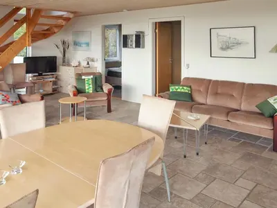 a living room with a table and a couch at Holiday Home Simo - 250m from the sea by Interhome in Øsløs