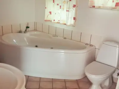a white bath tub in a bathroom with a toilet at Holiday Home Simo - 250m from the sea by Interhome in Øsløs