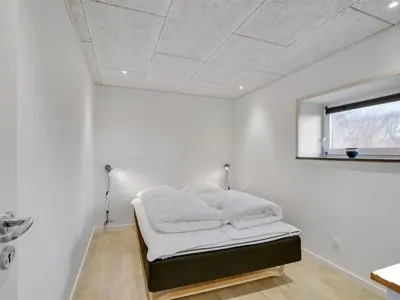 a white room with a bed in the corner at Holiday Home Markhild - 300m to the fjord by Interhome in Sønder Ydby