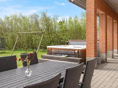 a patio with a table and a hot tub at Holiday Home Markhild - 300m to the fjord by Interhome in Sønder Ydby
