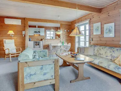 a living room with a couch and a table at Holiday Home Bjarnger - 200m from the sea by Interhome in Frøstrup