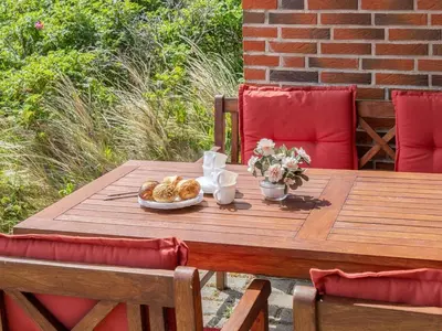 a wooden table with a plate of food on it at Holiday Home Bjarnger - 200m from the sea by Interhome in Frøstrup