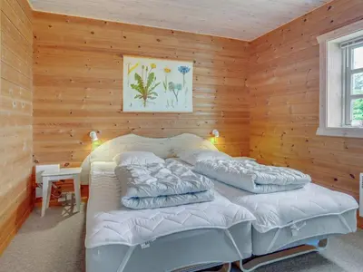 a bedroom with two beds in a wooden wall at Holiday Home Bjarnger - 200m from the sea by Interhome in Frøstrup