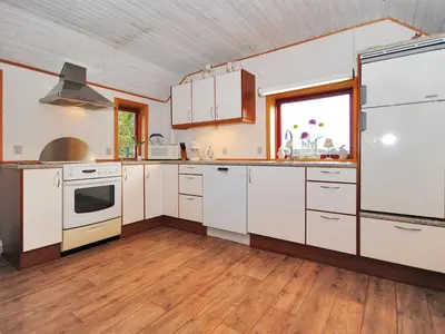 a kitchen with white appliances and a wooden floor at Holiday Home Palle - 2km from the sea by Interhome in Snedsted