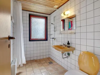 a bathroom with a sink and a toilet and a window at Holiday Home Atreju - 2km from the sea by Interhome in Bedsted Thy