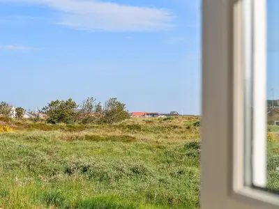 a view of a field of grass from a window at Holiday Home Wulfhard - 400m from the sea by Interhome in Frøstrup