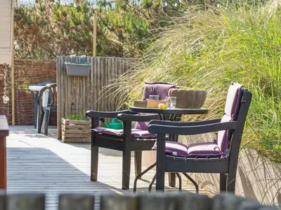 a patio with two chairs and a table on a deck at Holiday Home Wulfhard - 400m from the sea by Interhome in Frøstrup