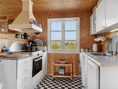 a kitchen with white cabinets and a window at Holiday Home Wulfhard - 400m from the sea by Interhome in Frøstrup