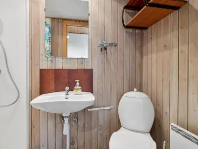 a bathroom with a toilet and a sink at Apartment Dineke - 200m to the fjord by Interhome in Vestervig