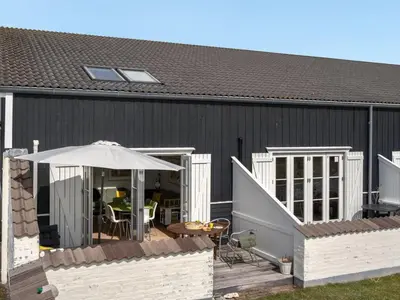 a black building with a patio and an umbrella at Apartment Siunde - 100m to the fjord by Interhome in Vestervig