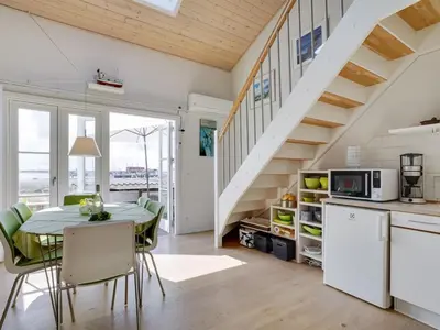 a kitchen and dining room with a table and a staircase at Apartment Siunde - 100m to the fjord by Interhome in Vestervig