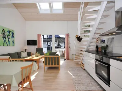 a kitchen and living room with a table and a dining room at Apartment Benta - 150m to the fjord by Interhome in Vestervig