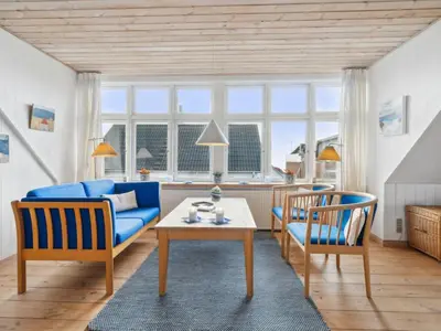 a living room with a blue couch and two chairs at Holiday Home Gertina - 40m to the fjord by Interhome in Vestervig