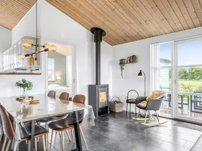 a dining room with a table and chairs and a fireplace at Holiday Home Selke - 300m to the fjord by Interhome in Vestervig