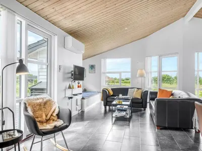 a living room with couches and chairs and windows at Holiday Home Selke - 300m to the fjord by Interhome in Vestervig