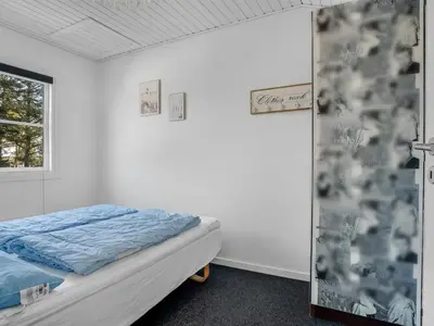 a bedroom with a bed and a window at Apartment Eleen - 100m to the fjord by Interhome in Vestervig