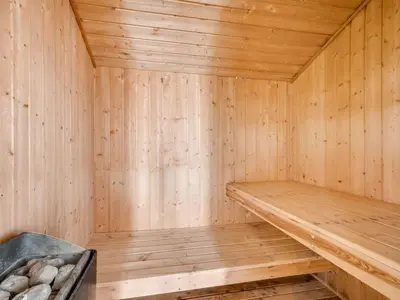 a wooden sauna with a bench in it at Holiday Home Sulevi - 200m to the fjord by Interhome in Vestervig