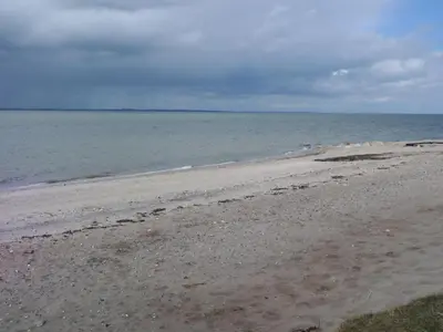 an empty beach with the ocean in the background at Holiday Home Assarina - 300m to the fjord by Interhome in Vinderup