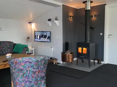 a living room with a couch and a wood stove at Holiday Home Assarina - 300m to the fjord by Interhome in Vinderup