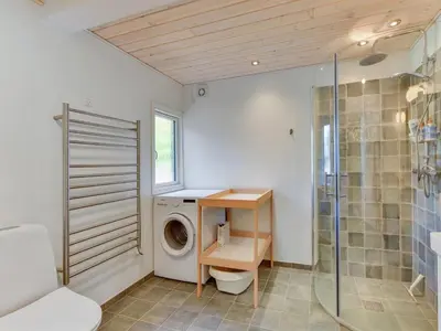 a bathroom with a washing machine and a shower at Holiday Home Sebastian - 100m to the fjord by Interhome in Thyholm