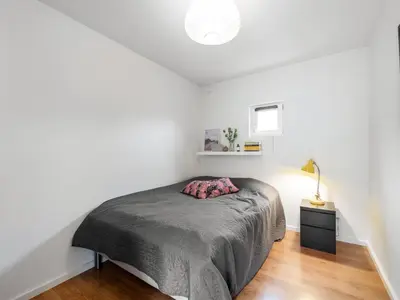 a bedroom with a bed and a lamp on a wooden floor at Holiday Home Tenna - 250m to the fjord by Interhome in Højslev