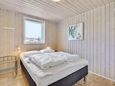 a bedroom with a large bed in a room with a window at Holiday Home Nahel - 150m to the fjord by Interhome in Vinderup