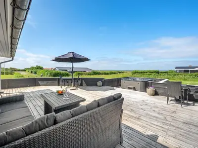 a patio with a couch and a table and an umbrella at Holiday Home Nahel - 150m to the fjord by Interhome in Vinderup