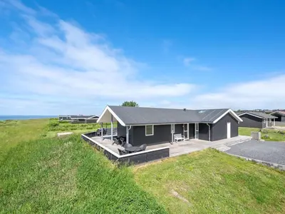 a house with a large deck in a field at Holiday Home Nahel - 150m to the fjord by Interhome in Vinderup