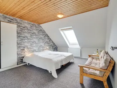a bedroom with a bed and a brick wall at Holiday Home Rahild - 2km to the fjord by Interhome in Thyholm
