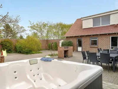 a white bath tub in a backyard with a table and chairs at Holiday Home Rahild - 2km to the fjord by Interhome in Thyholm