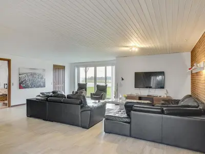 a living room with two couches and a flat screen tv at Holiday Home Rahild - 2km to the fjord by Interhome in Thyholm