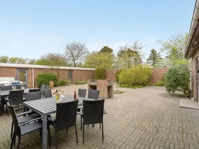 a patio with tables and chairs and a brick wall at Holiday Home Rahild - 2km to the fjord by Interhome in Thyholm